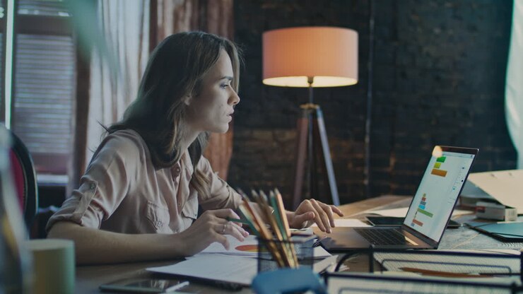 Concentrated businesswoman working on laptop computer at office