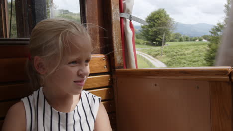 girl looking out the window of a vintage train