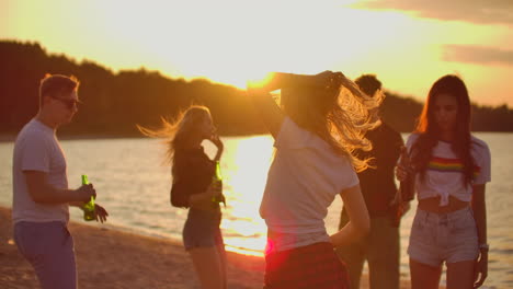 the young people dance in circles on the open air party with beer. it is crazy and cool beach party with the best friends in the good mood.