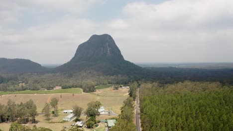 Narrow-Provincial-Road-Leading-to-The-Glass-House-Mountains-In-Australia---aerial-shot