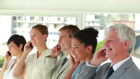 business people of all ages smiling on the phone