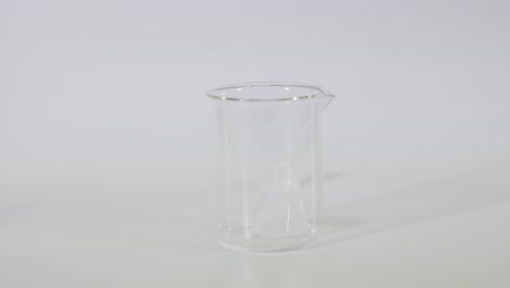 un cubo de hielo cayendo en un vaso de vidrio