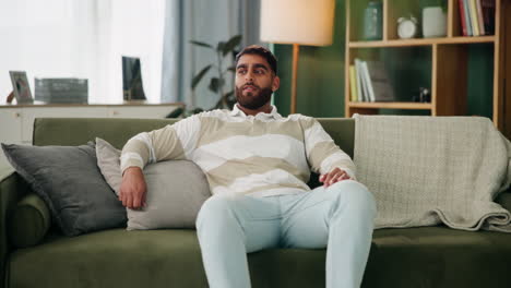 man relaxing on a couch indoors