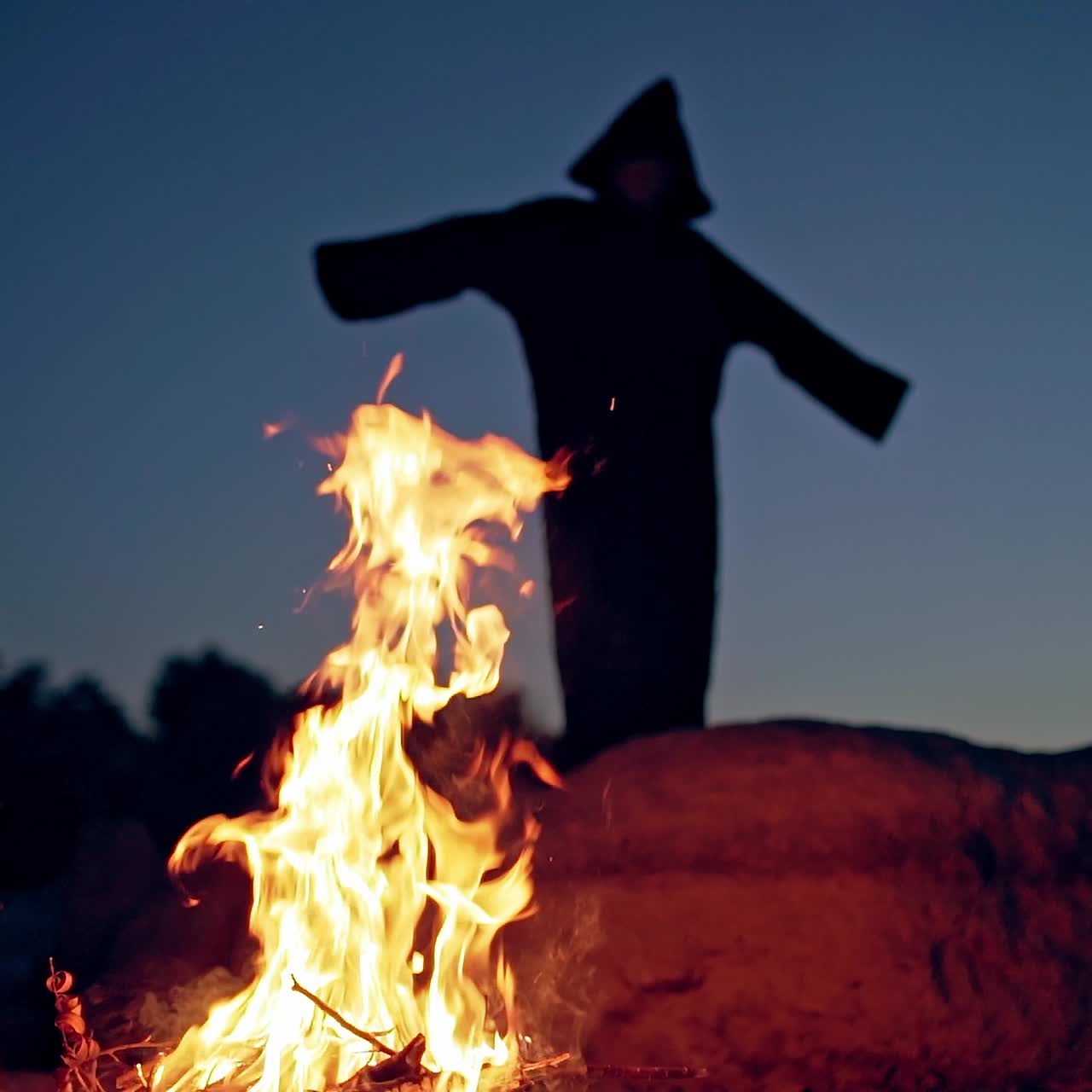 Witch by night fire in forest