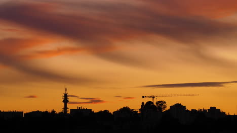 Sunset-over-Montpellier-construction-site-cranes-and-antenna-orange-sky-France