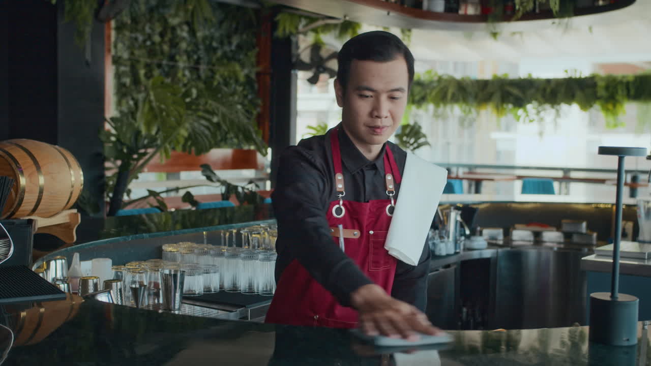 Asian Bar Worker in Apron behind Counter