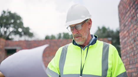 construction worker inspecting brick wall