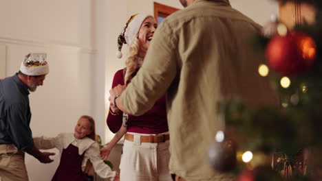 familia bailando alrededor del árbol de navidad