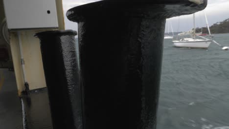 Pan-Around-Bollards-In-Window-Of-Boat-To-Reveal-Ocean-And-Boats,-Tasmania,-Australia