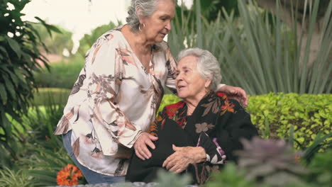 senior woman kissing sister on head