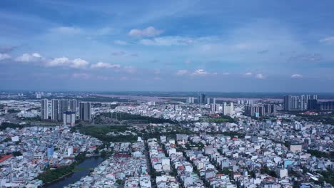 slow pan and reveal of ho chi minh city, vietnam on clear sunny day featuring saigon river and city skyline from drone