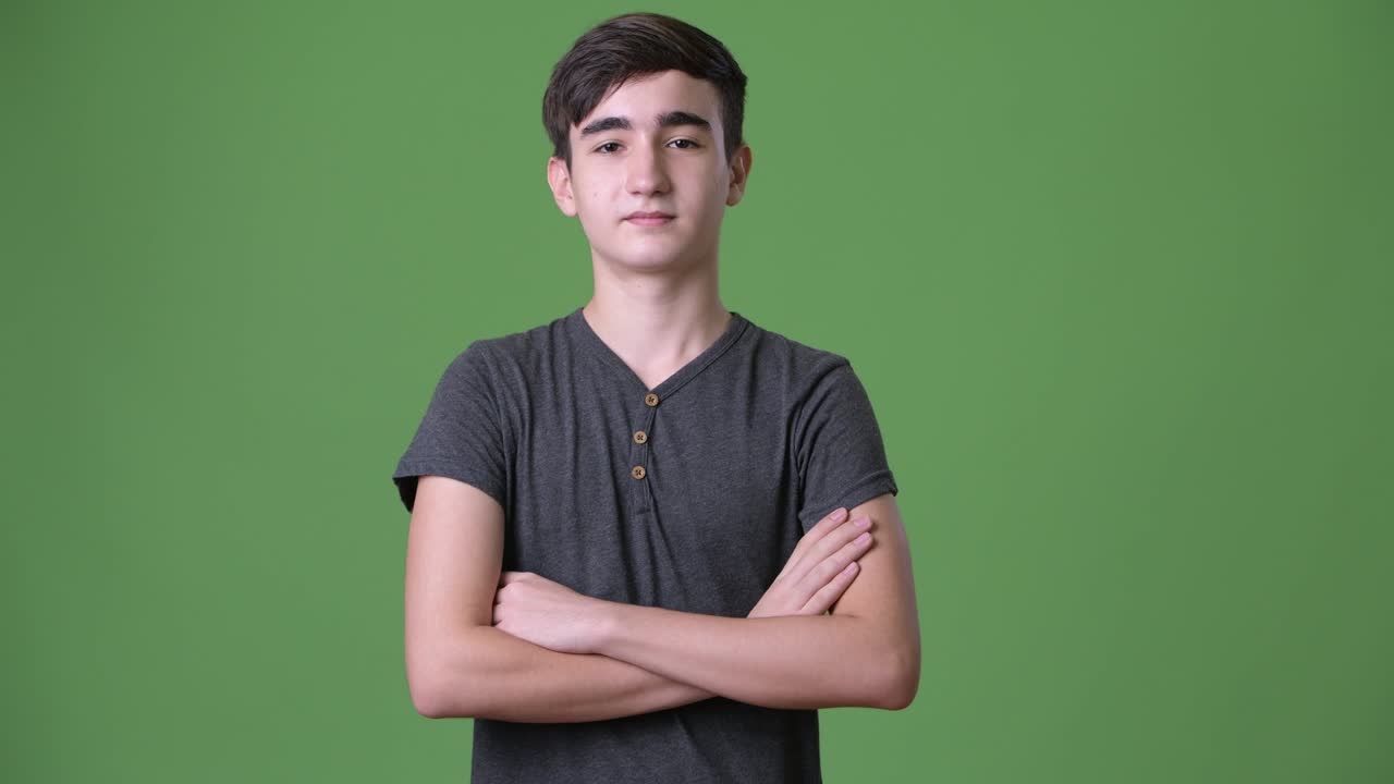 초록색 배경에 젊은 잘생긴 이란 십대 소년