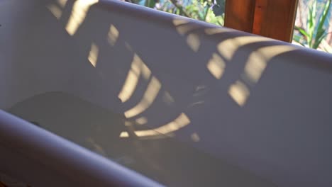 Bathtub-slowly-filling-up,-with-afternoon-sunrays-shinning-through-a-lake-Atitlan-aparment,-Guatemala,-Slow-motion