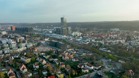 Aerial-the-dynamic-urban-landscape-of-Oliwa,-a-district-of-Gdańsk,-contrast-between-modern-high-rise-architecture-and-traditional-housing,-Olivia-Business-Centre-towering-over-the-scene