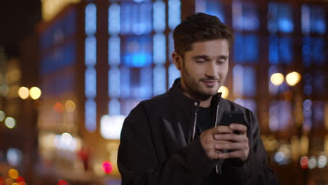 calm man texting mobile phone on dark street. relaxed guy typing smartphone