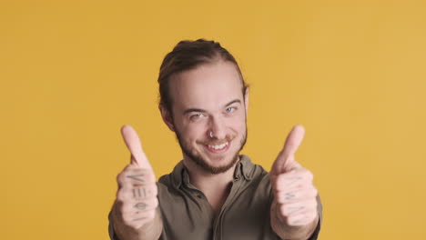 caucasian young man showing thumbs up to the camera.