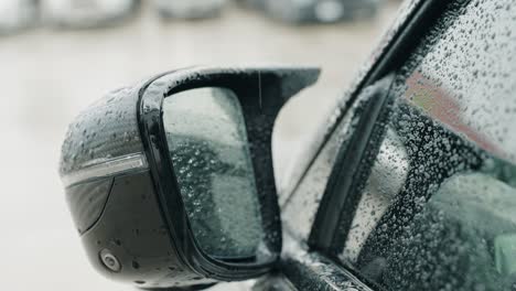 driver-side-mirror-covered-with-rain-droplets-while-pouring-rain