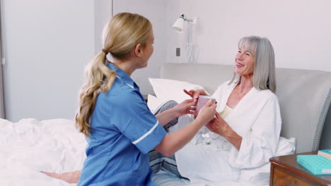 nurse brings hot drink to senior woman on home visit