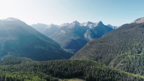 aerial push in shot of the san juan mountain range. featuring beautiful trees and snow capped mountains.