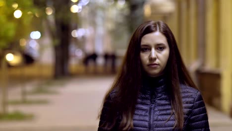 retrato de una mujer joven en una gran ciudad por la noche. una mujer joven está caminando por la ciudad nocturna.