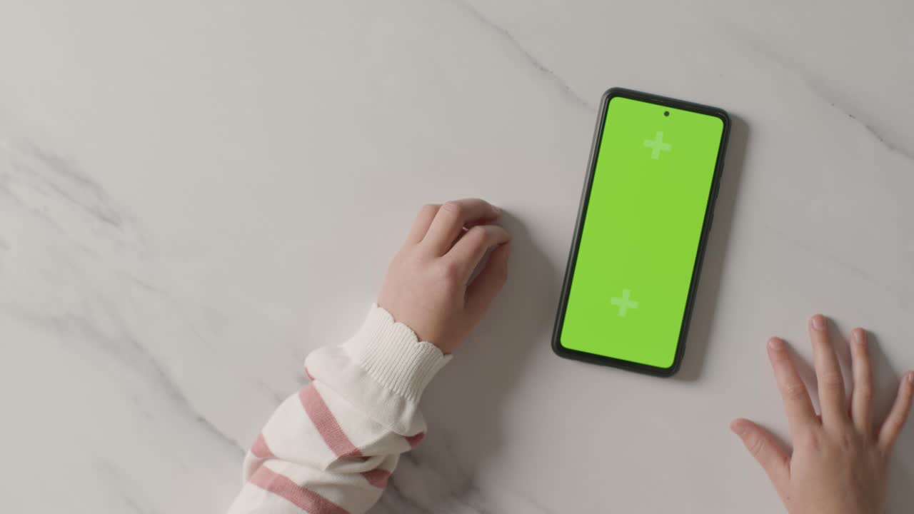 초록색 화면 휴대전화 로딩을 기다리는 참을성이 없는 아이의 오버헤드 스튜디오  ⁇