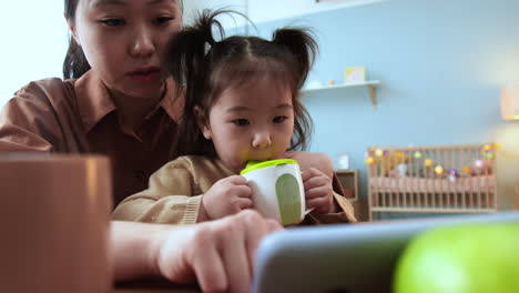 Asiatische-Frau-Sitzt-Mit-Ihrem-Baby-An-Einem-Tisch