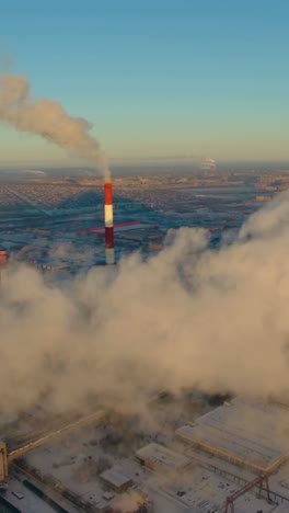 industrial facility in winter with smoke emissions