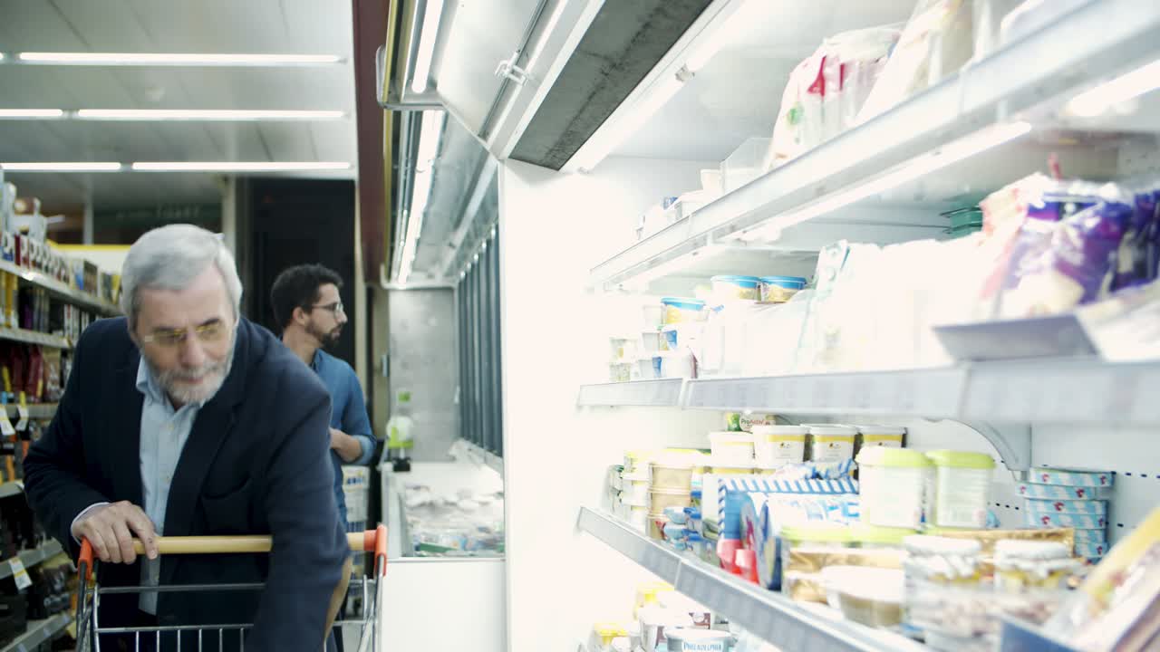 가게 에서 유제품 을 선택 하는 성숙 한 남자