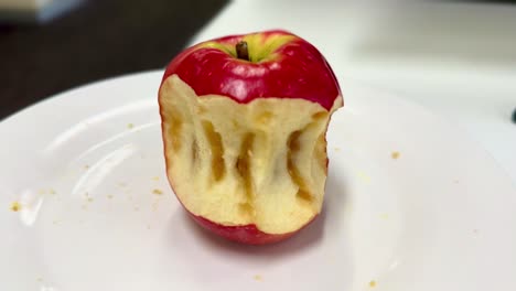 rotten bad apple - close medium side, top view - on a white plate