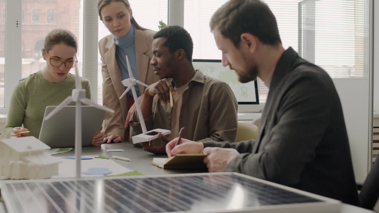 многонациональная бизнес-команда обсуждает проект по возобновляемым источникам энергии в офисе 1