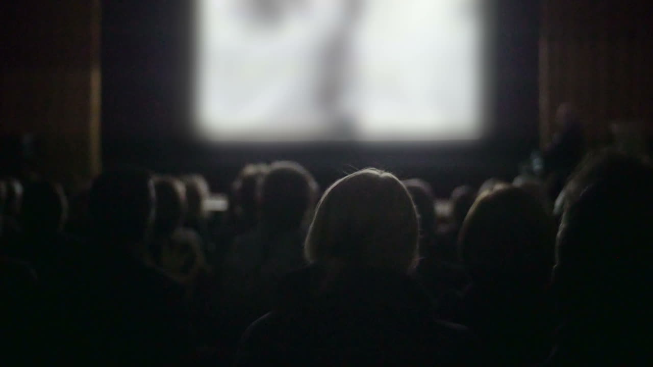 映画館で映画を見ている人々