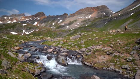 woman hiking near a creek in the highlands of colorado