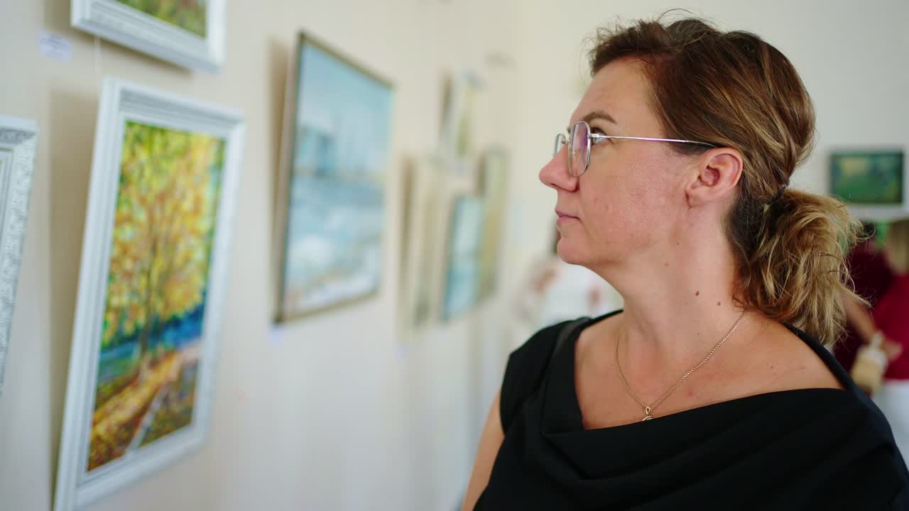 A Woman Observing Art in an Exhibition: Engaging with Beautiful Landscapes and Paintings that Capture Nature's Essence and Insightful Moments of Reflection