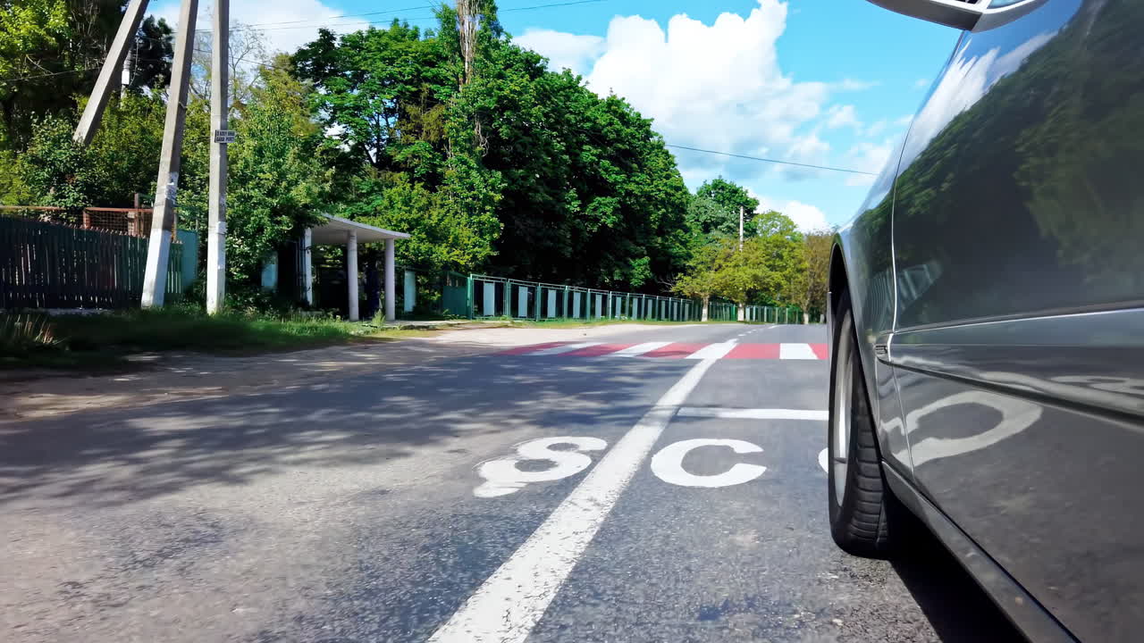 Driving car on the road in a village of Moldova. Low side shot. Slow motion