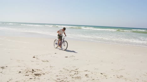 man riding a bicycle at beach on a sunny day 4k