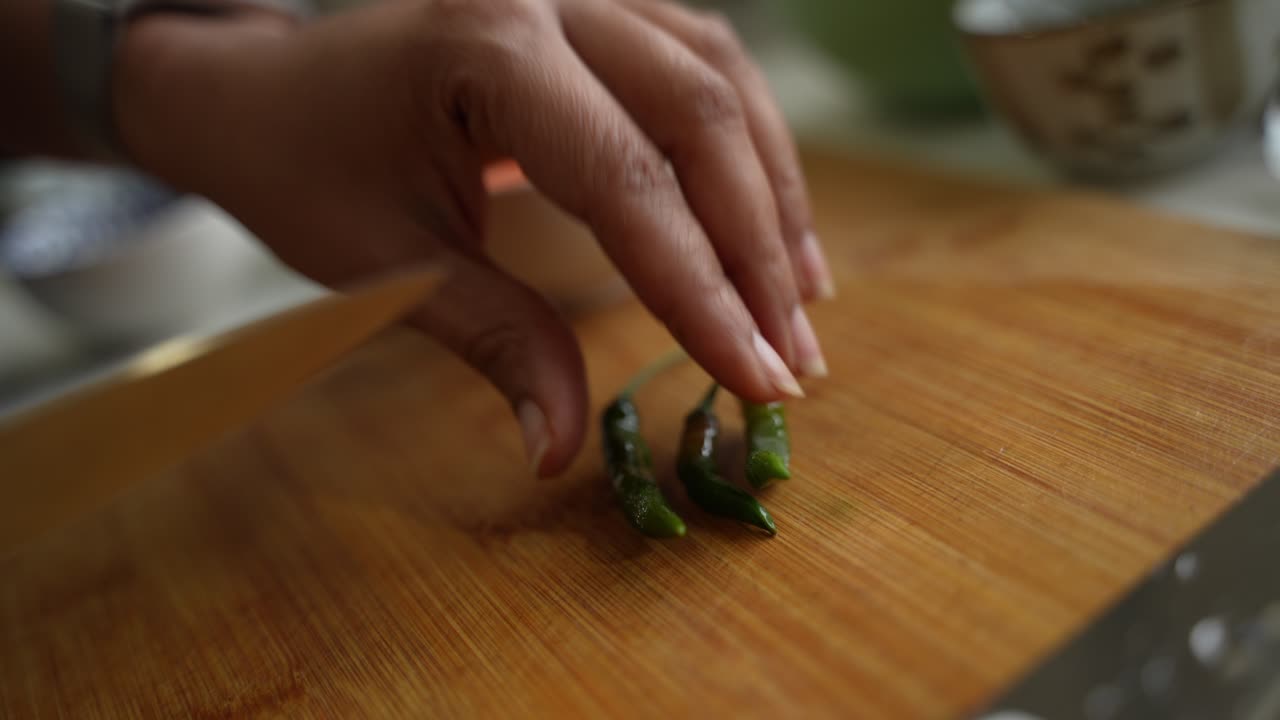 Woman's Hands Chopping Green Chili Peppers