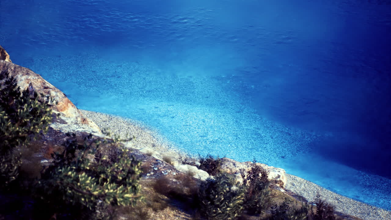 Crystal clear water along the rocky shoreline with lush greenery nearby