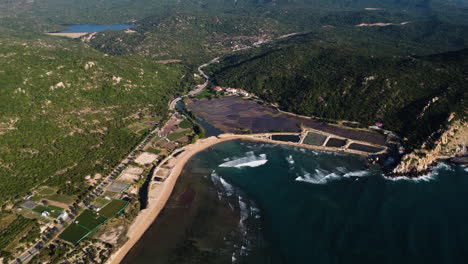 Aerial-seascape-of-Hang-rai-village-in-Vietnam-popular-tourist-destination-in-ninh-thuan-province,-mountains-cliff-bay-with-ocean-pristine-water