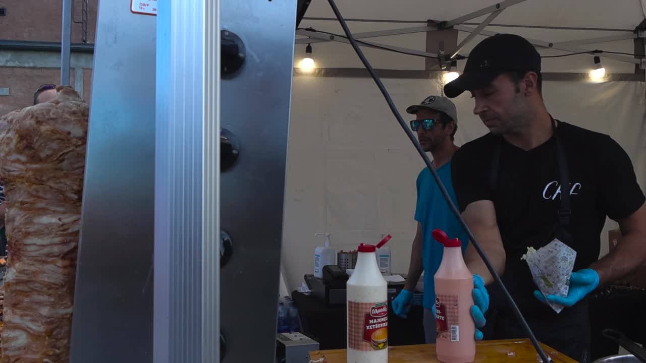 Chef preparing döner kebab or gyros at an outdoor food stall
