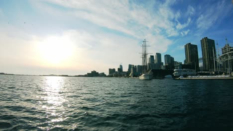 coastal cityscape with moored caravel and water reflection. static