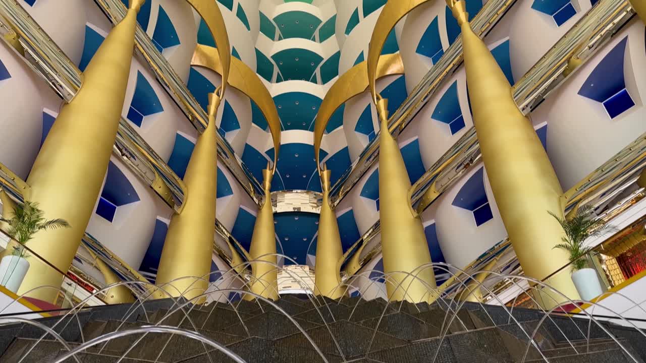 The Burj Al Arab Tower luxury hotel fountain, entrance, and lobby in Dubai, United Arab Emirates - tilt up to reveal the spacious interior
