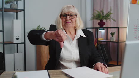 Upset-senior-business-woman-showing-thumbs-down-sign-gesture,-disapproval,-dissatisfied,-dislike