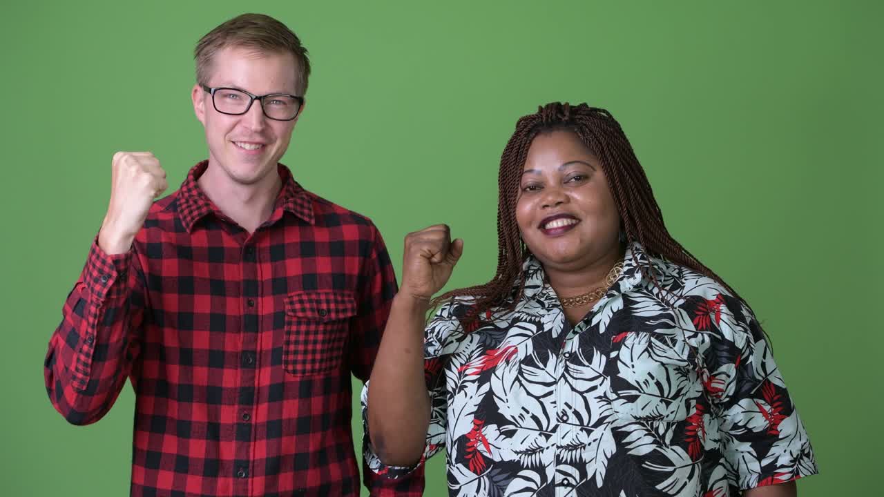 Donna africana in sovrappeso e giovane uomo scandinavo insieme su sfondo verde