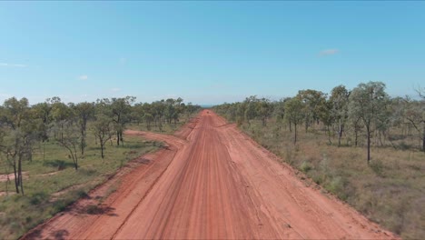 un camino rojo polvoriento en el interior con cielo azul en el fondo