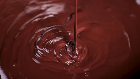 close-up of spoon stirring rich melted chocolate smoothly