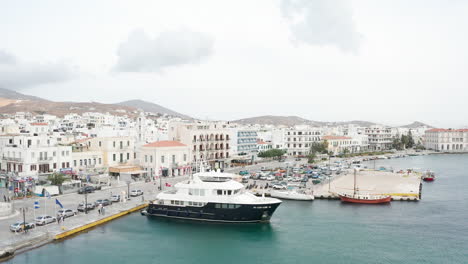 Drone-flight-over-teal-water-at-Port-of-Tinos-on-the-island-of-Tinos-in-Greece