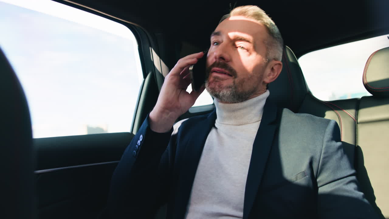 Man in Suit Talking on Phone in Car