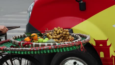 person arranging various fruits on a bike cart