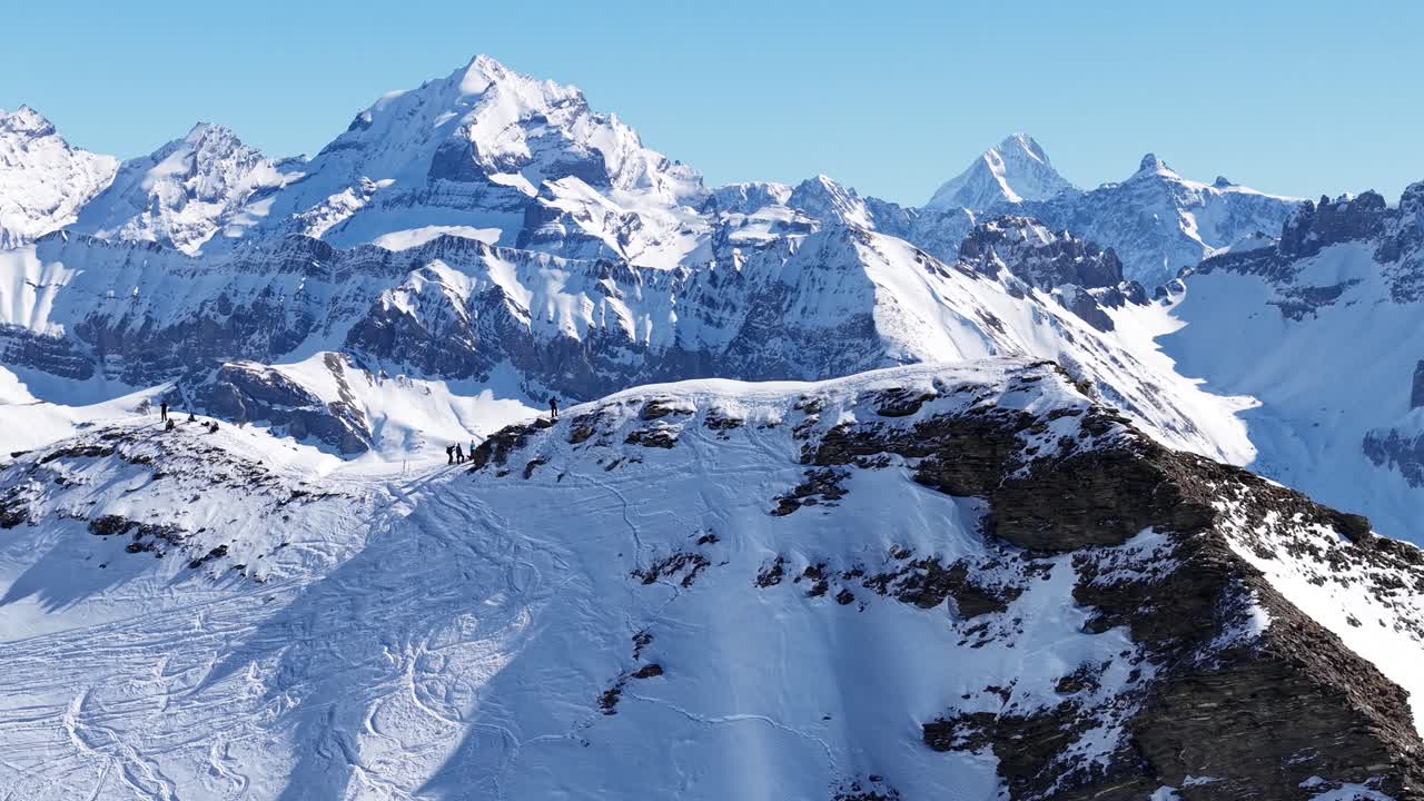 orbiting mountain peak with a drone with panoramic view in the swiss mountains on a sunny winter day.