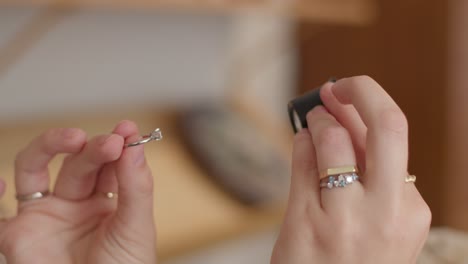 anillo de diamantes siendo mirado en el monóculo de la multitud por una mujer